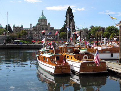 Parliament Buildings and classic boats in Victoria BC inner harbour